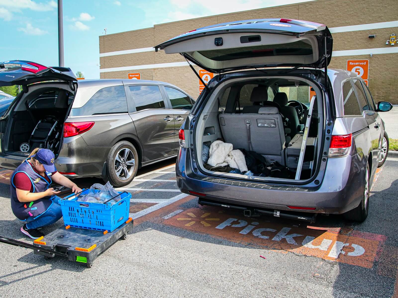 BOPIS retail: as shown here at Walmart with an employee loading up two mini-vans with BOPIS groceries.